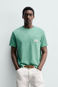 T-SHIRT REGULAR FIT COM BOLSO E REMENDO
