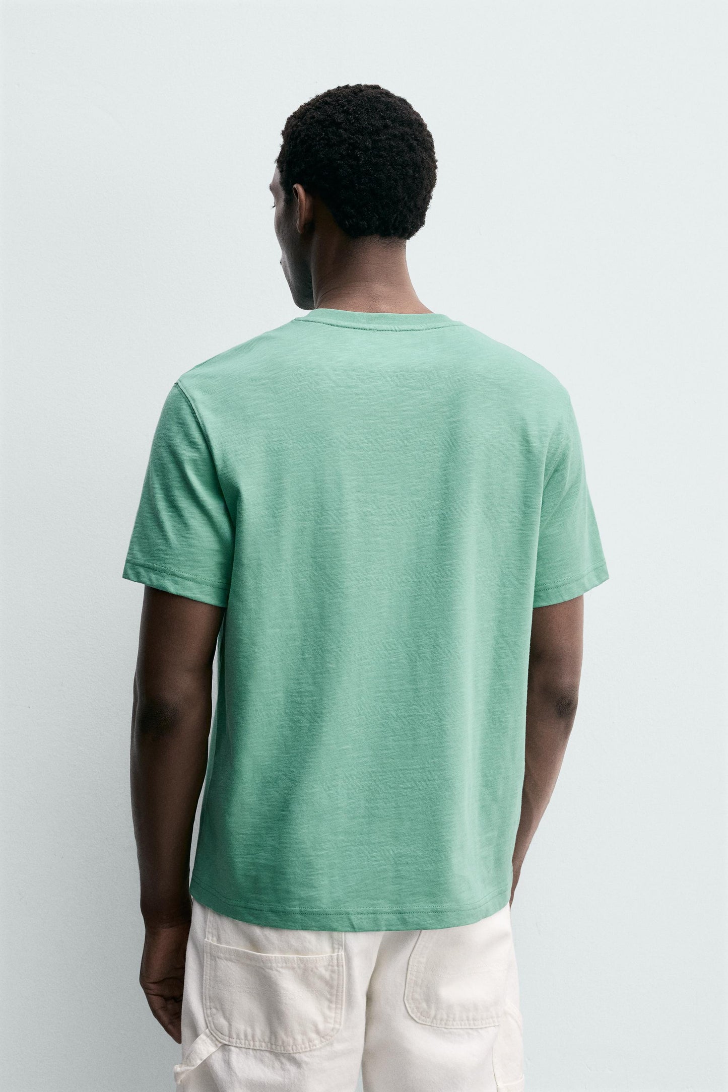 T-SHIRT REGULAR FIT COM BOLSO E REMENDO