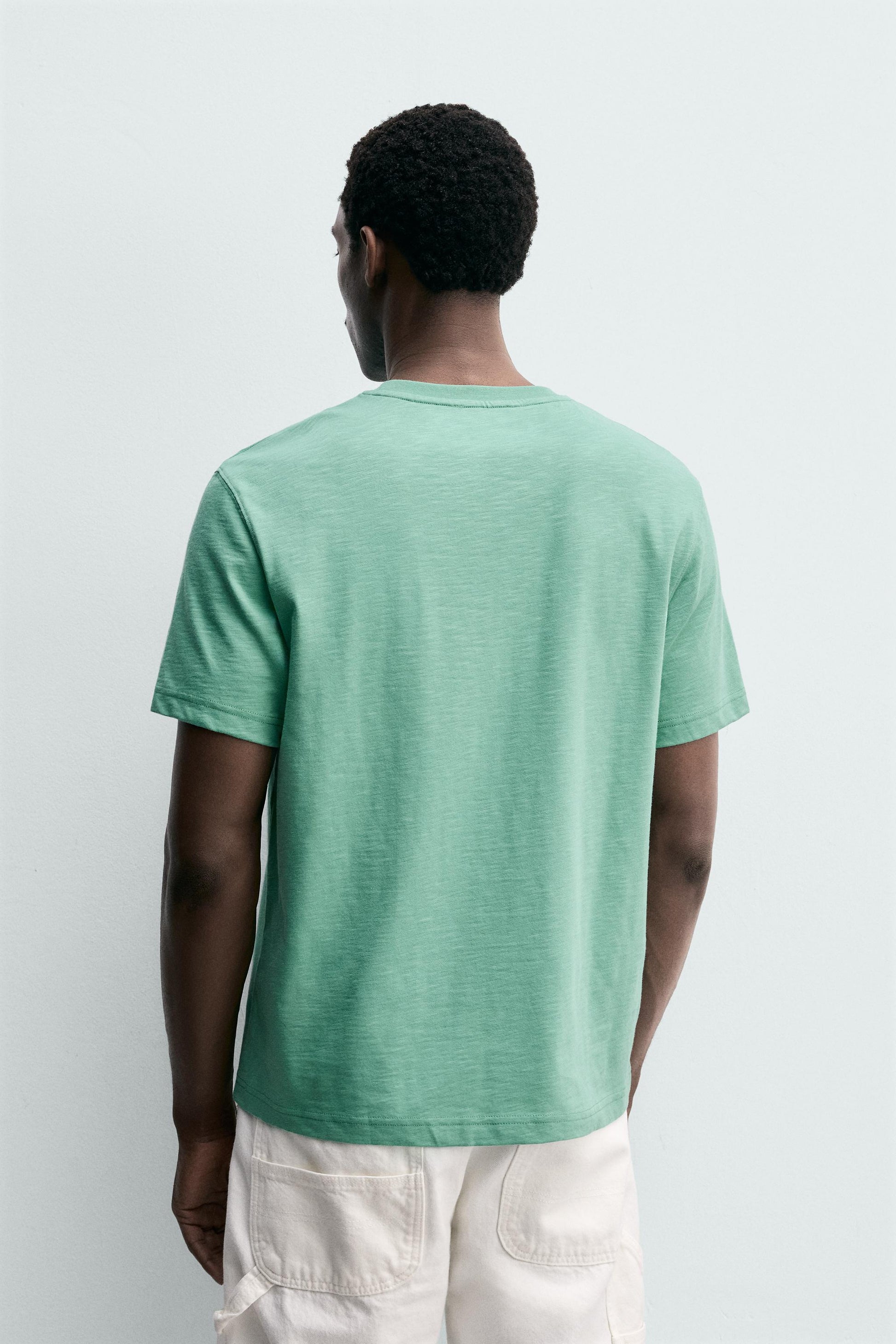 T-SHIRT REGULAR FIT COM BOLSO E REMENDO