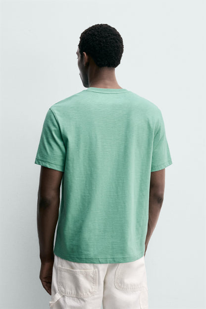 T-SHIRT REGULAR FIT COM BOLSO E REMENDO