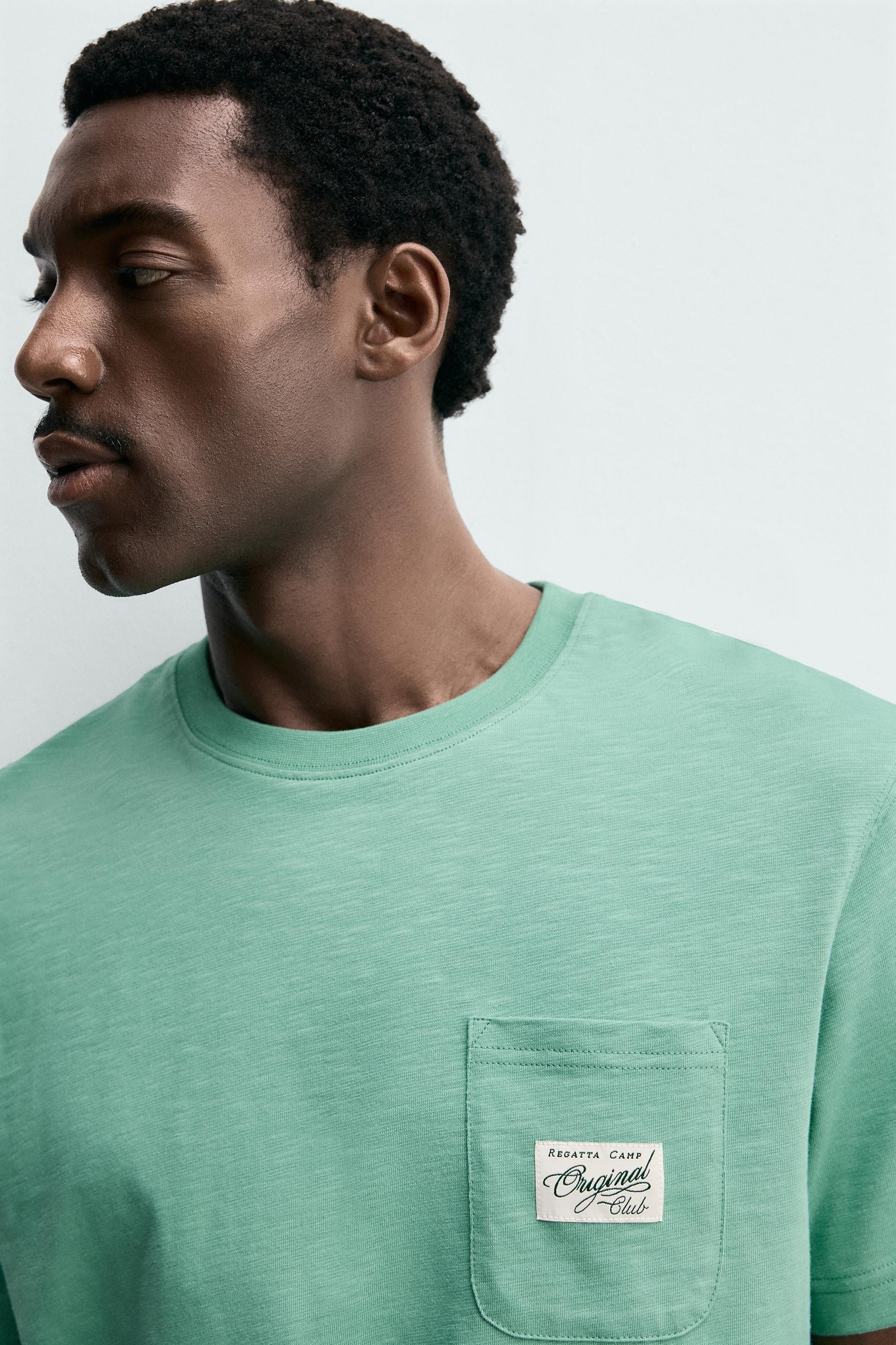 T-SHIRT REGULAR FIT COM BOLSO E REMENDO