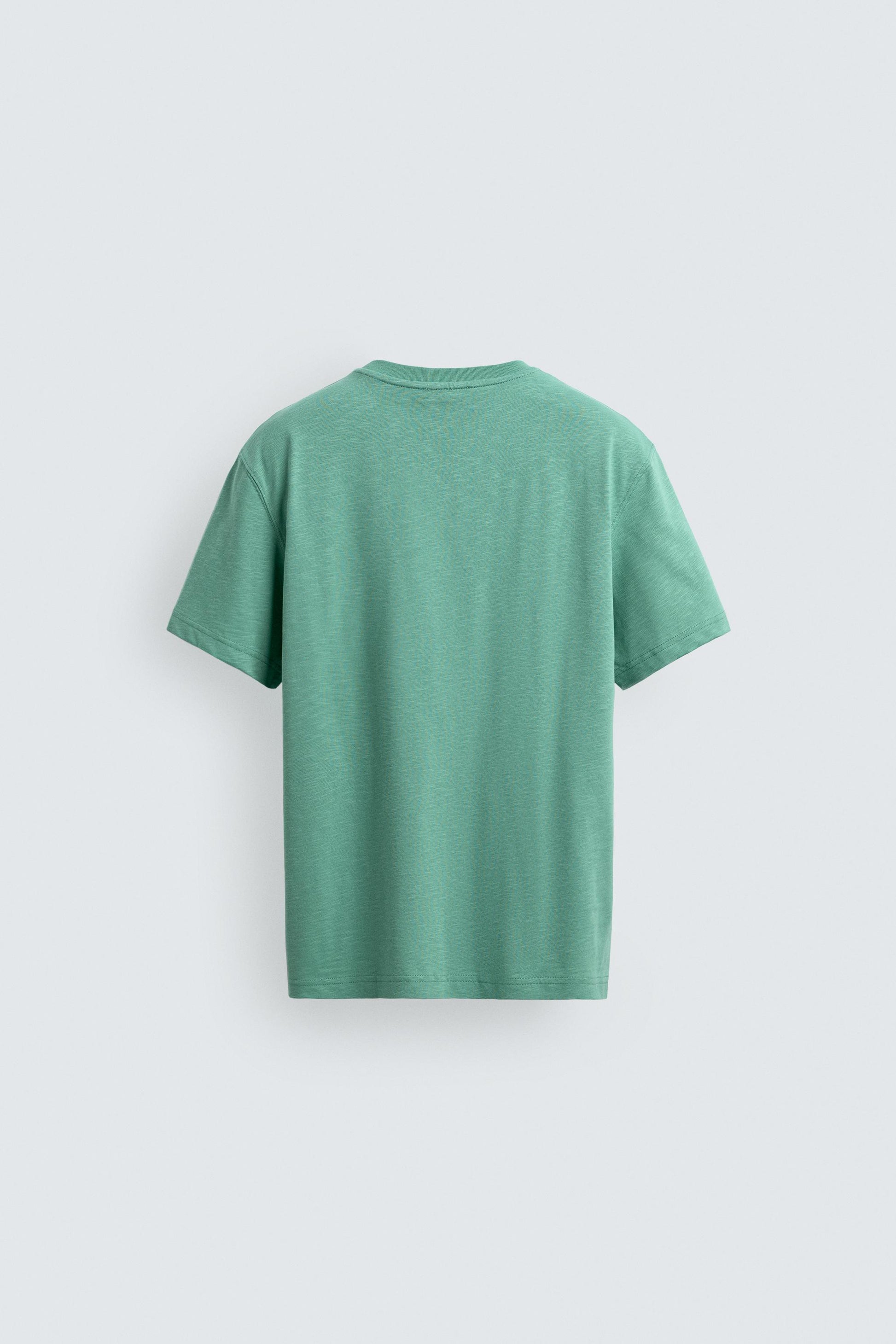 T-SHIRT REGULAR FIT COM BOLSO E REMENDO
