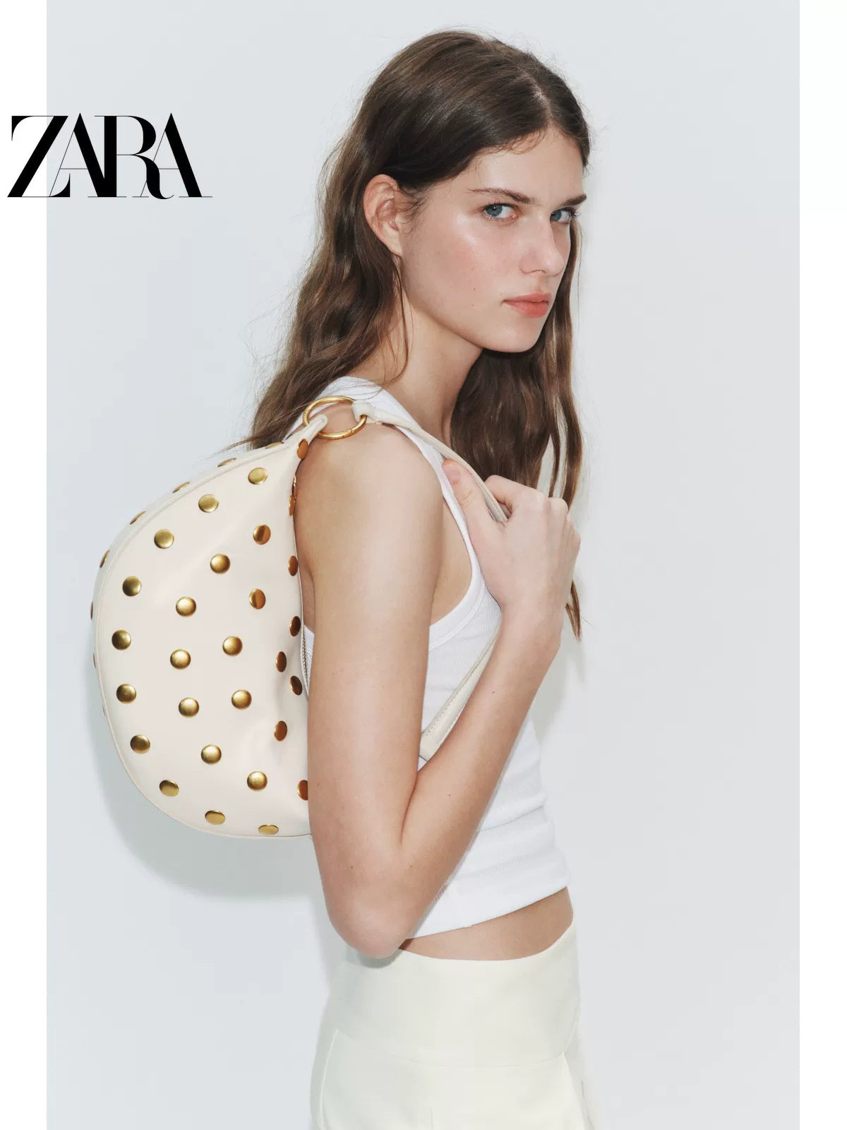Bolsa feminina ZARA, lançamento da coleção verão 2026, com detalhes em rebites e zíper com argola metálica, modelo ombro, código 6094810 850.