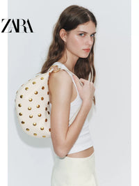 Bolsa feminina ZARA, lançamento da coleção verão 2026, com detalhes em rebites e zíper com argola metálica, modelo ombro, código 6094810 850.
