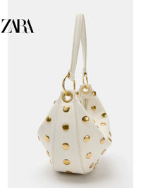 Bolsa feminina ZARA, lançamento da coleção verão 2026, com detalhes em rebites e zíper com argola metálica, modelo ombro, código 6094810 850.