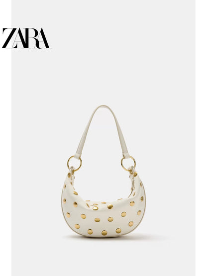 Bolsa feminina ZARA, lançamento da coleção verão 2026, com detalhes em rebites e zíper com argola metálica, modelo ombro, código 6094810 850.